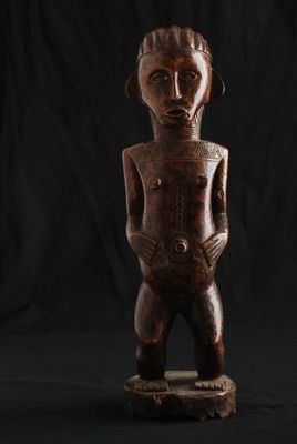 une statue en bois représentant un homme debout sur un skateboard