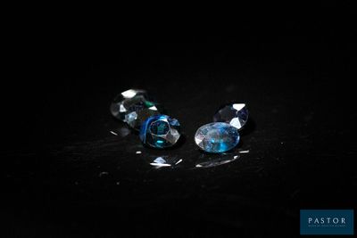 pair of blue and clear glass beads on a black surface
