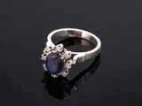 a sapphire and diamond ring on a black surface