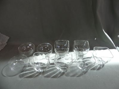 several empty wine glasses lined up on a table in front of a curtain