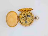 a gold pocket watch with a gold case on it