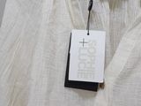a close up of a white shirt on a hanger with a tag