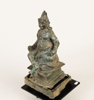 an image of a statue of a woman sitting on top of a pile of books