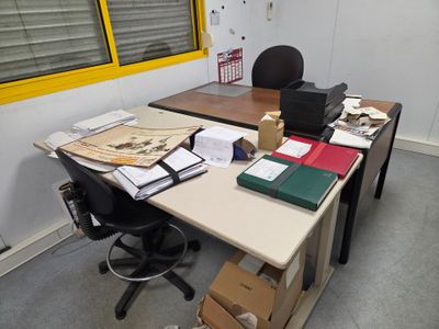un bureau recouvert de papiers et une chaise
