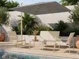an outdoor patio with a pool, lounge chairs, and umbrella