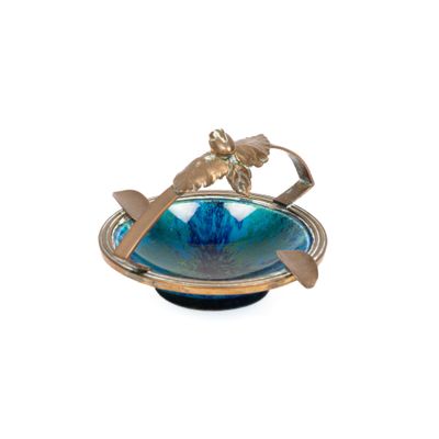 un bol bleu orné d'un oiseau, avec une cuillère à l'intérieur