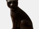 statue of a black cat sitting on a white surface