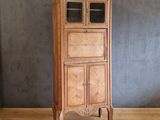 une vieille armoire en bois avec une porte vitrée, posée sur un parquet en bois massif