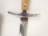 a knife hanging on a wall with a wooden handle