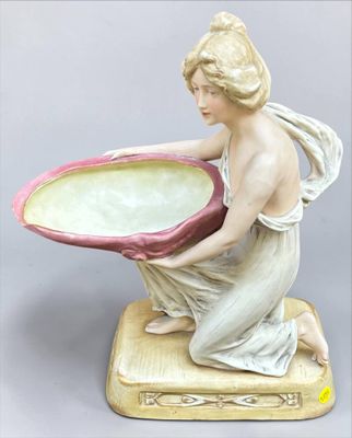 a figurine of a woman holding a bowl