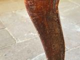 a wooden elephant that is standing on a stone floor