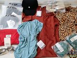 beaucoup de vêtements et un chapeau posés sur une table