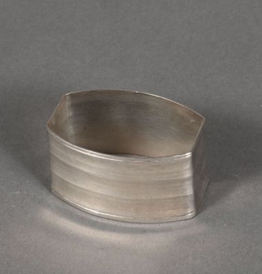 sterling silver ring with a curved design on a plain surface