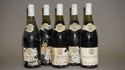 six bouteilles de vin sont alignées sur une table