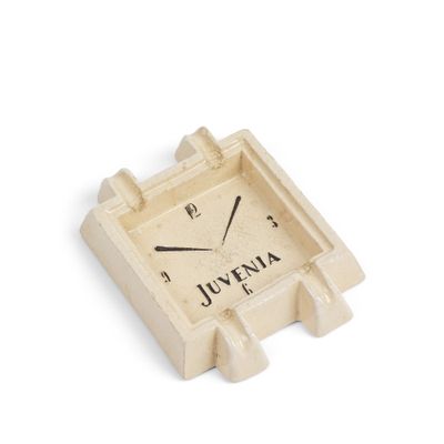 une petite horloge accrochée sur un mur blanc