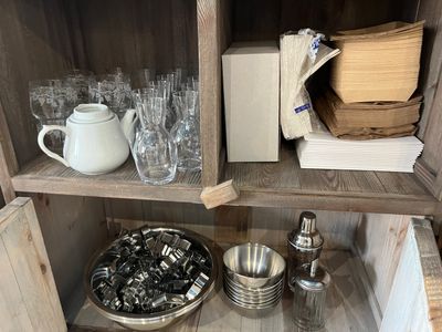 une étagère en bois sur laquelle sont posés de nombreux verres et assiettes