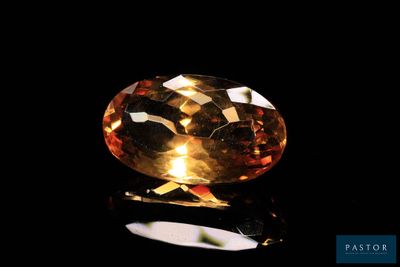 a yellow sapphire stone on a black surface