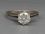 a close up of a diamond ring on a gray surface