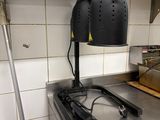 une lampe noire posée sur un plan de travail en métal dans une cuisine