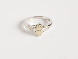 une image d'une bague en diamant sur une surface blanche