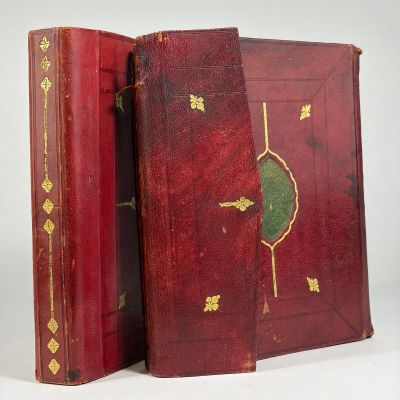 un vieux livre à la couverture rouge ornée de motifs dorés