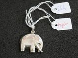 un pendentif en forme d'éléphant en argent auquel est attachée une étiquette de prix