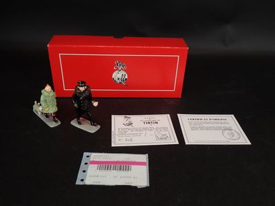 des figurines représentant un homme et une femme debout à côté d'une boîte rouge