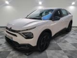 une voiture blanche garée dans une pièce au sol en damier