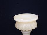 a white vase with a flower design on it