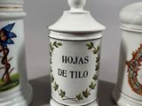 three ceramic jars with decorative designs on them sitting on a table