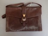 brown leather purse with a gold buckle on a white background