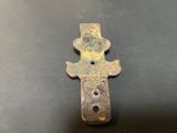 an old bronze cross on a black surface