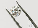 un gros plan d'un diamant tenu par une pince