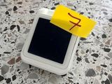 une petite boîte blanche sur laquelle est collé un autocollant jaune