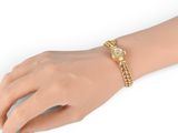 a close up of a person ' s hand wearing a gold bracelet