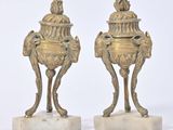 paire de vases anciens en laiton posés sur des socles en marbre et surmontés d'un oiseau
