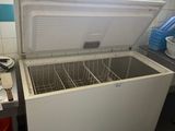 a white chest freezer sitting in a kitchen next to a window