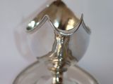 a silver plate with a silver candle holder on it