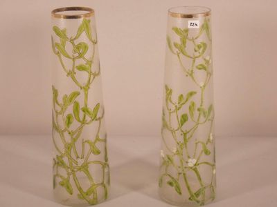 two tall vases with plants in them on a table