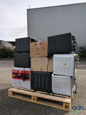 a stack of appliances on a pallet in front of a building