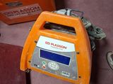 une petite machine orange posée par terre à côté d'autres objets