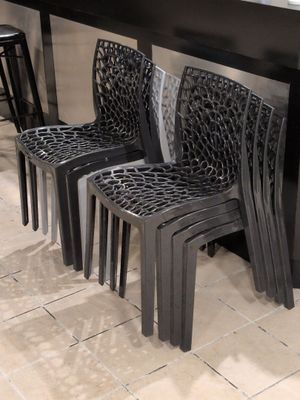 quatre chaises en plastique posées devant un comptoir