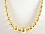 un gros plan d'un collier de perles dorées sur un mannequin