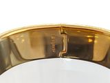 an image of a close up of a gold bracelet on a white surface