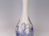 an old blue and white vase with a gold rim on a white background