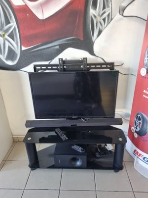 une télévision à écran plat posée sur un meuble devant un tableau