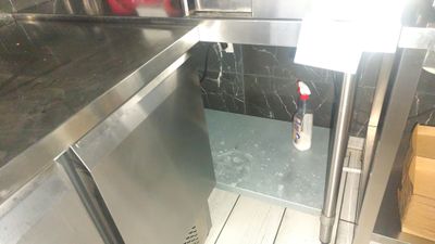 a stainless steel refrigerator in the corner of a kitchen
