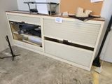 a white cabinet with two doors and a cork board on the wall