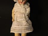 an old doll with a white dress and yellow shoes on a black background