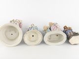 four porcelain figurines of people sitting on a white surface